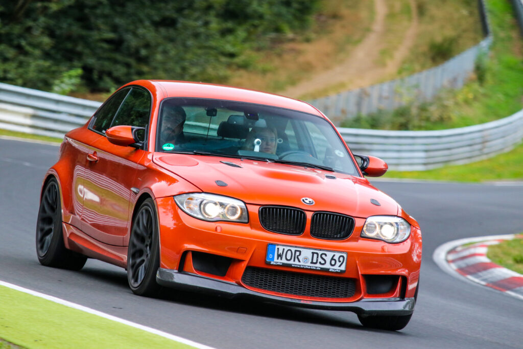 Orangefarbener BMW 1M Coupé mit TKEngineering Tuning auf der Rennstrecke